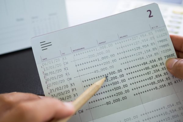 Finger holding pencil Point Data Numeric withdrawal amount on Accounting Bank book.