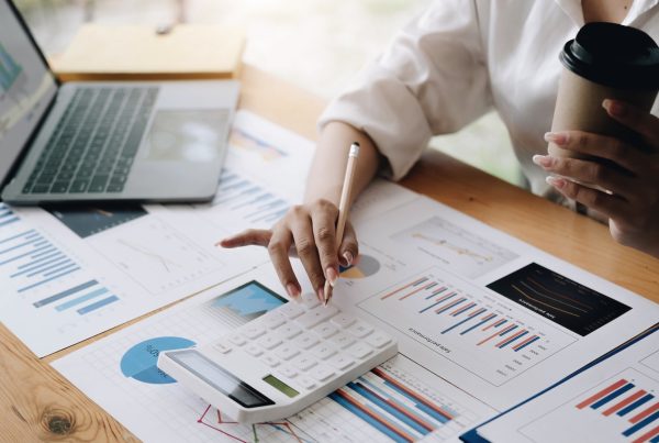 Close up Business woman using calculator and laptop for outsourced bookkeeping