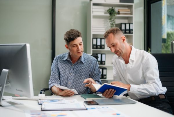 A business owner reviewing compliance deadlines with an advisor — calm, organised, professional.