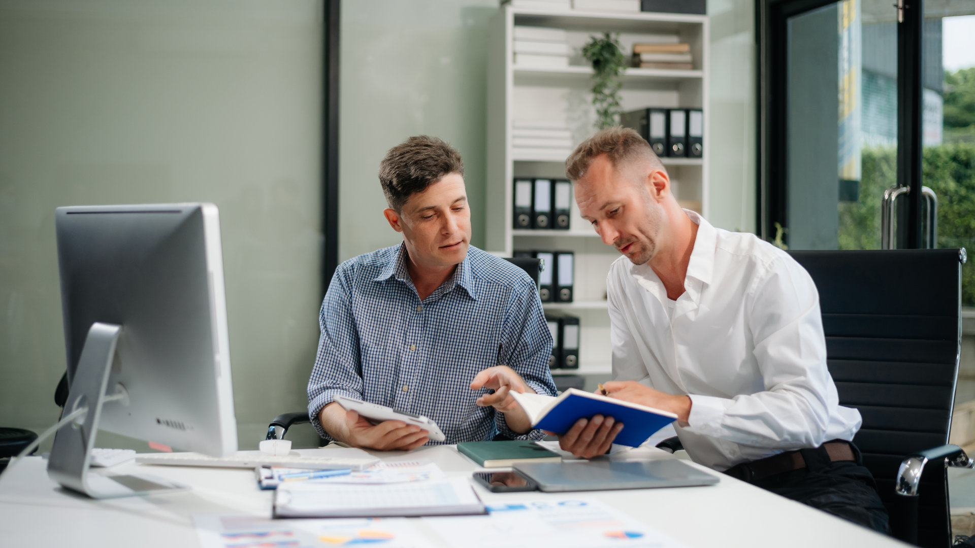 A business owner reviewing compliance deadlines with an advisor — calm, organised, professional.